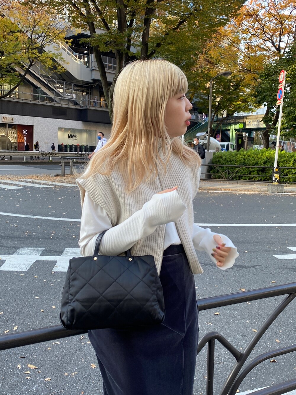 グレー系のスカート、ホワイト系のベスト、ホワイト系のTシャツ/カットソーを着用したレディースの秋コーディネートの5枚目の写真