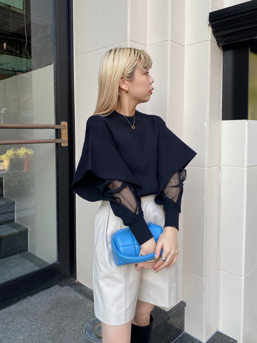 ブラック系のニット/セーター、ホワイト系のその他パンツ、ブラック系のブーツを着用したレディースの冬コーディネートの5枚目の写真