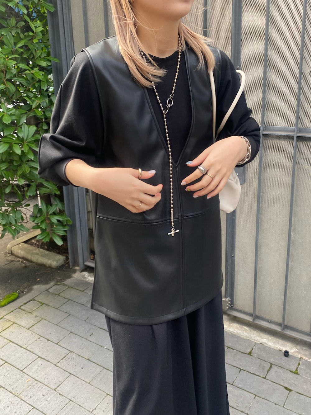 ブラック系のワンピース、ブラック系のベスト、ホワイト系のブーツを着用したレディースの秋コーディネートの5枚目の写真