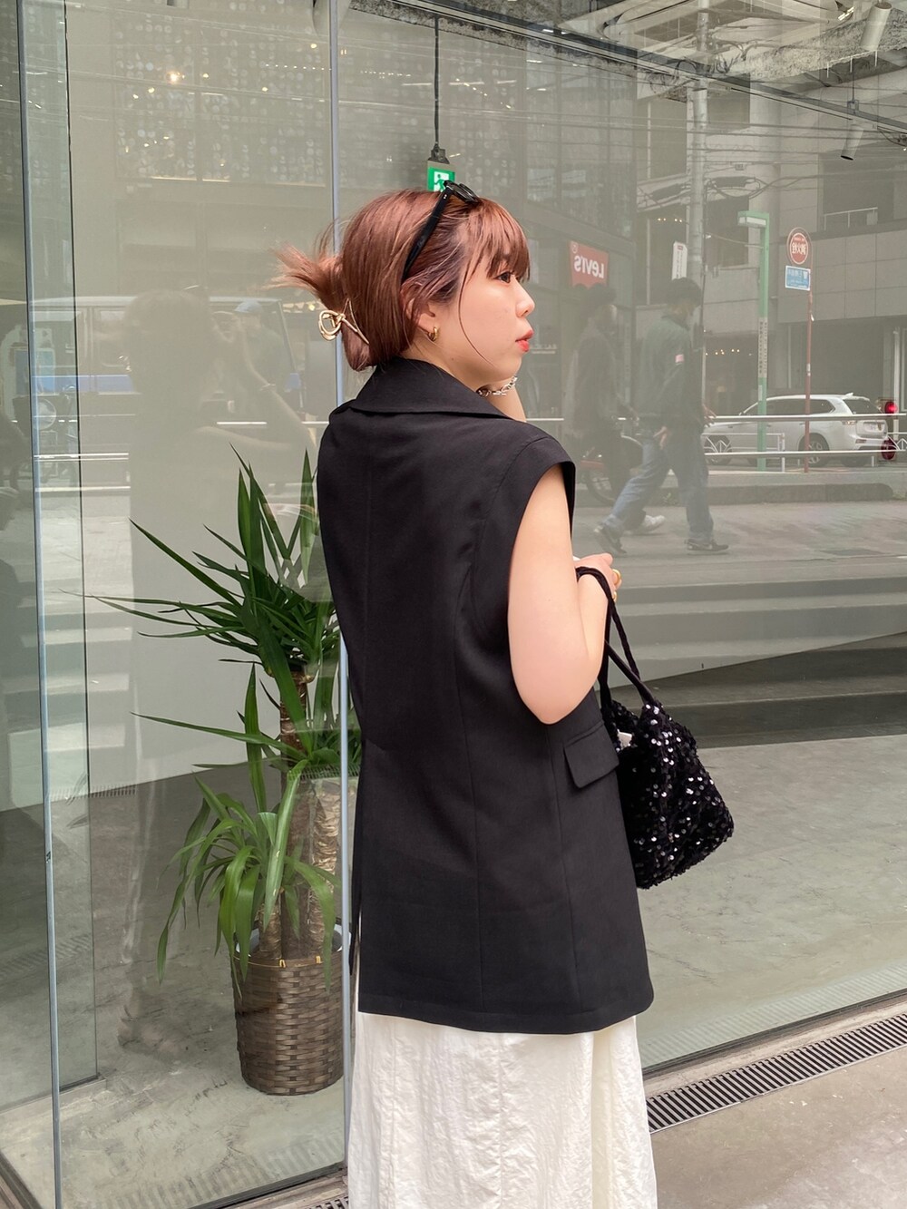 ブラック系のベスト、ホワイト系のワンピース、ブラック系のその他シューズを着用したレディースの春コーディネートの6枚目の写真