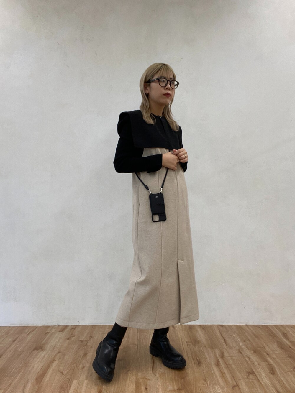 ブラック系のTシャツ/カットソー、ブラック系のワンピース、ブラック系のブーツを着用したレディースの冬コーディネートの2枚目の写真