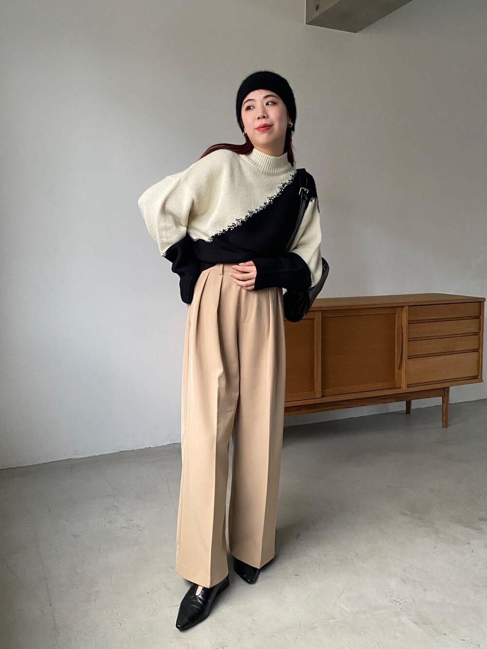 ホワイト系のニット/セーター、ベージュ系のその他パンツ、ブラック系のその他シューズを着用したレディースの秋コーディネートの3枚目の写真