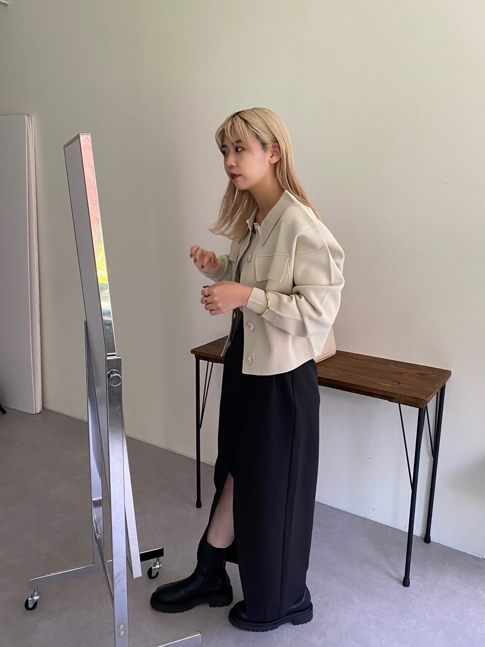 ホワイト系のブルゾン、ブラック系のブーツ、ホワイト系のトートバッグを着用したレディースの秋コーディネートの3枚目の写真