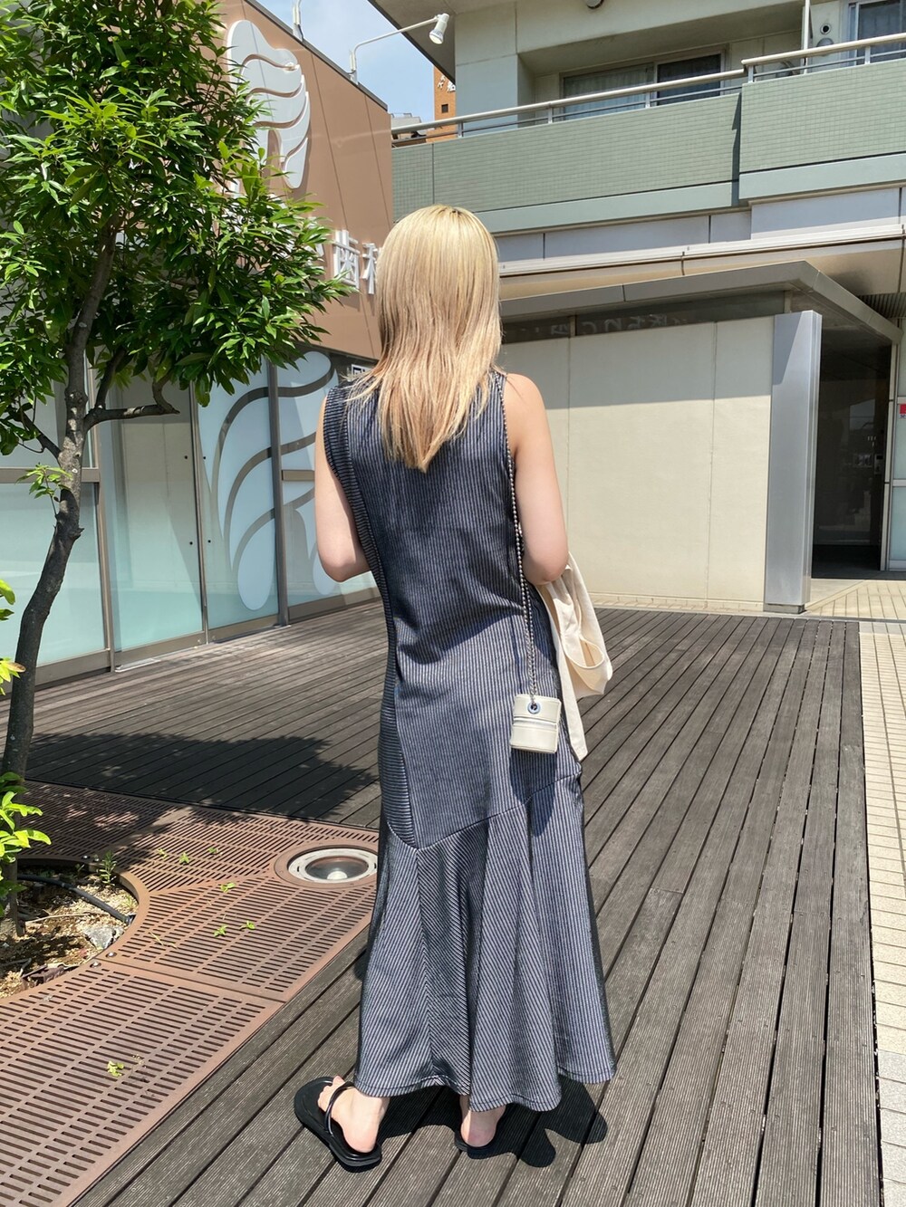 ブラック系のワンピース、ホワイト系のベスト、ホワイト系のショルダーバッグを着用したレディースの夏コーディネートの4枚目の写真