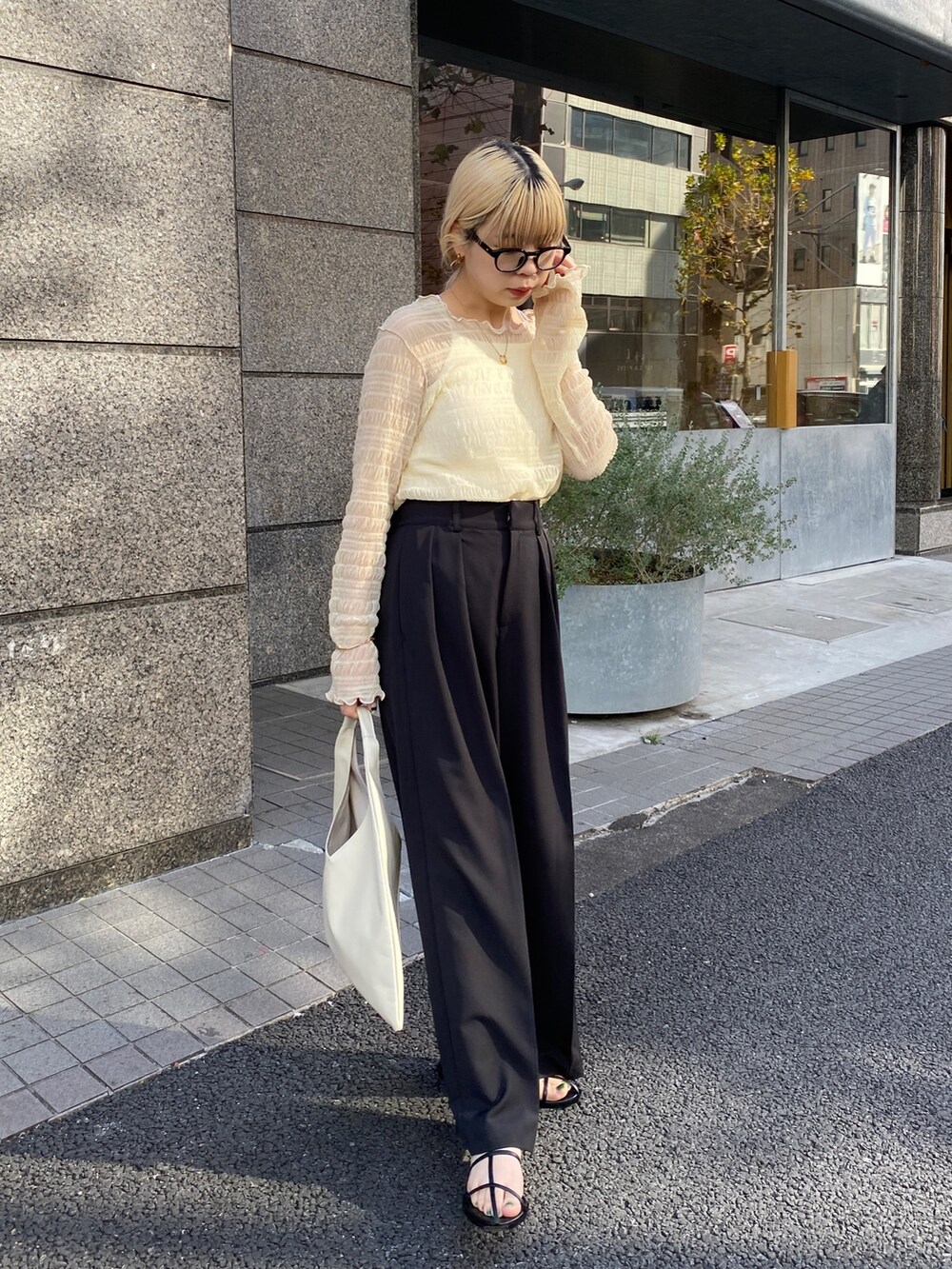 ベージュ系のTシャツ/カットソー、ブラック系のその他パンツ、ホワイト系のサンダルを着用したレディースの冬コーディネートの3枚目の写真