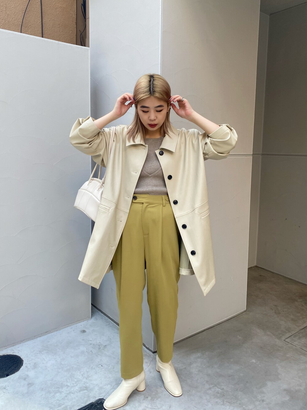 ベージュ系のカバーオール、イエロー系のその他パンツ、ホワイト系のブーツを着用したレディースの冬コーディネートの3枚目の写真