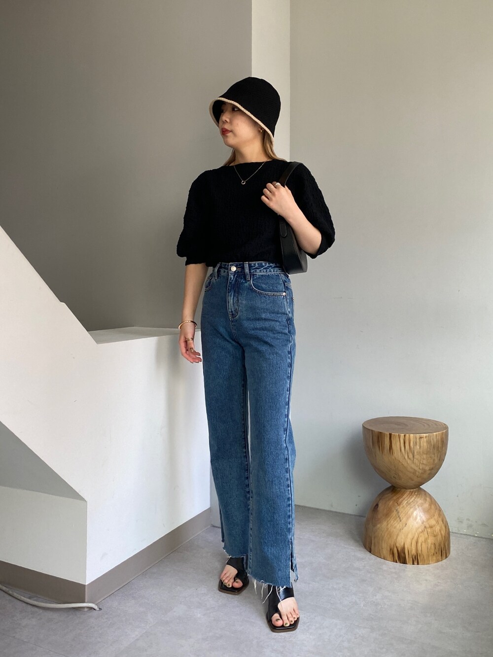 ブラック系のTシャツ/カットソー、ブルー系のデニムパンツ、ブラック系のシューズを着用したレディースの春コーディネートの2枚目の写真