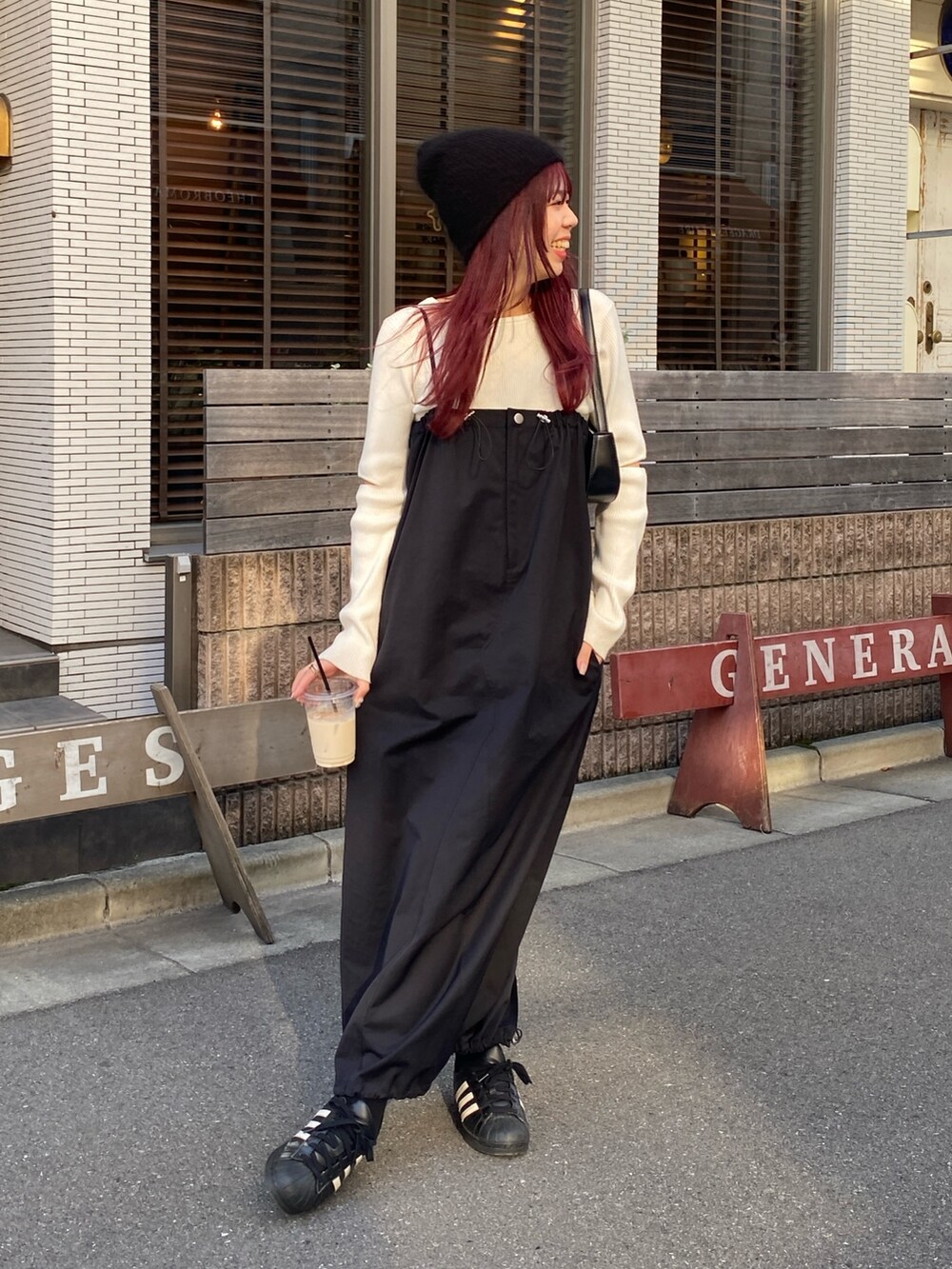 ホワイト系のニット/セーター、ブラック系のワンピース/ドレス、ブラック系のスニーカーを着用したレディースの秋コーディネートの2枚目の写真