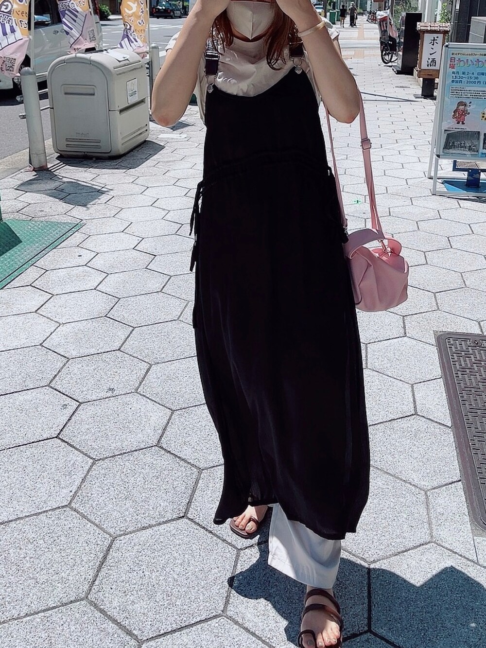 ピンク系のショルダーバッグ、ベージュ系のTシャツ/カットソー、ブラウン系のサンダルを着用したレディースの秋コーディネートの2枚目の写真