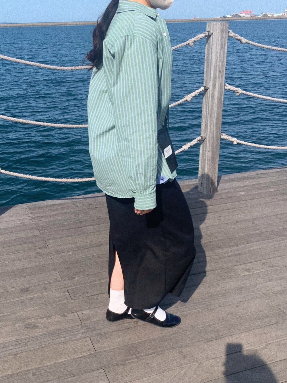 ブラック系のスカート、ブラック系のバレエシューズ、ブラック系のバッグを着用したレディースの春コーディネートの2枚目の写真