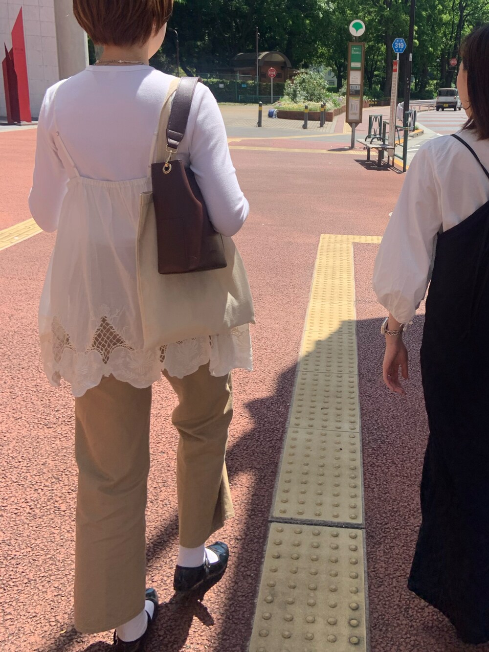 ブラック系のチノパンツ、ブラック系のバレエシューズ、ホワイト系のシャツ/ブラウスを着用したレディースの春コーディネートの2枚目の写真