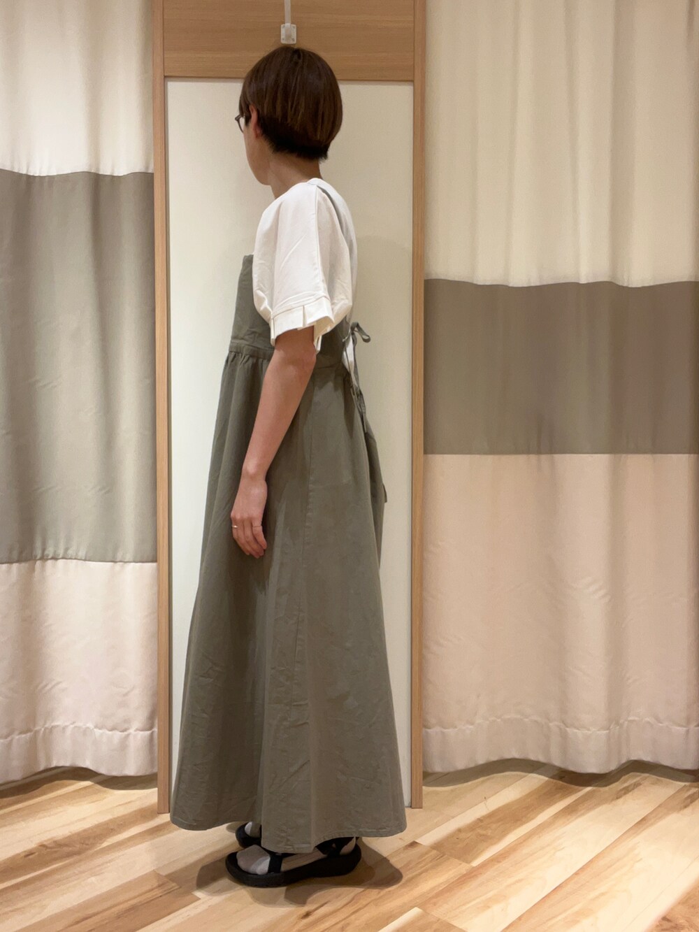 グリーン系のワンピース、ホワイト系のTシャツ/カットソーを着用したレディースの春コーディネートの2枚目の写真