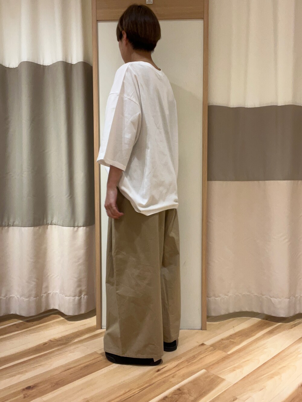 ブラック系のサンダル、ベージュ系のその他パンツ、ホワイト系のTシャツ/カットソーを着用したレディースの春コーディネートの5枚目の写真