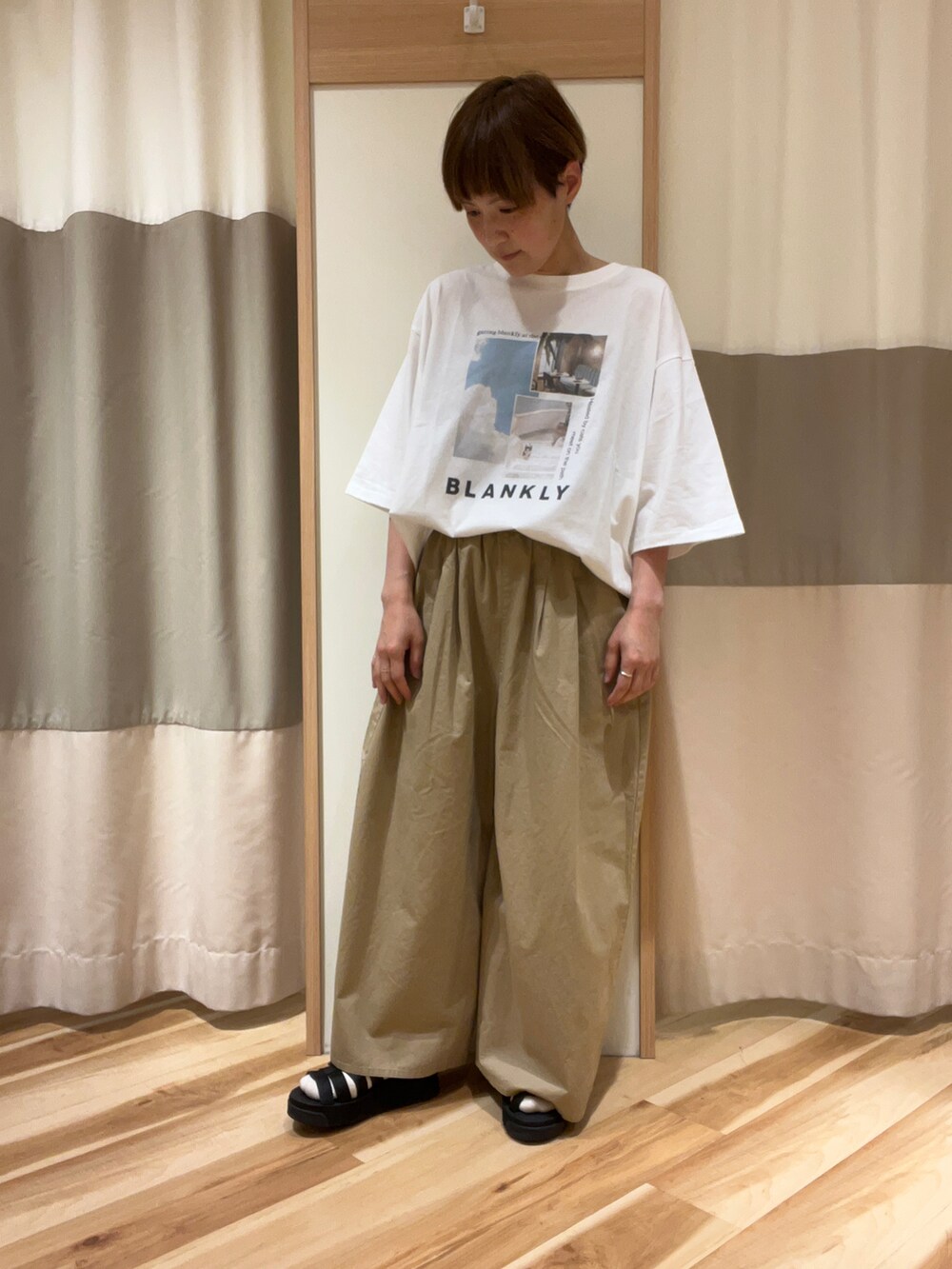 ブラック系のサンダル、ベージュ系のその他パンツ、ホワイト系のTシャツ/カットソーを着用したレディースの春コーディネートの4枚目の写真