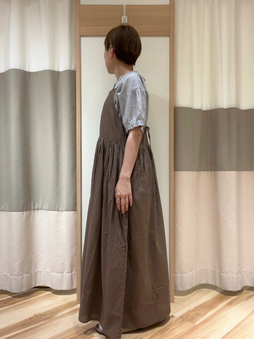 ブラウン系のワンピース、ブルー系のシャツ/ブラウス、ベージュ系のサンダルを着用したレディースの夏コーディネートの2枚目の写真