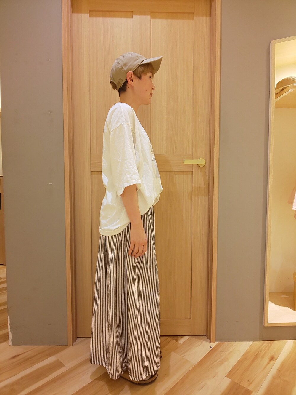 ブラウン系のサンダル、ブラウン系のその他パンツ、ホワイト系のTシャツ/カットソーを着用したレディースの春コーディネートの2枚目の写真