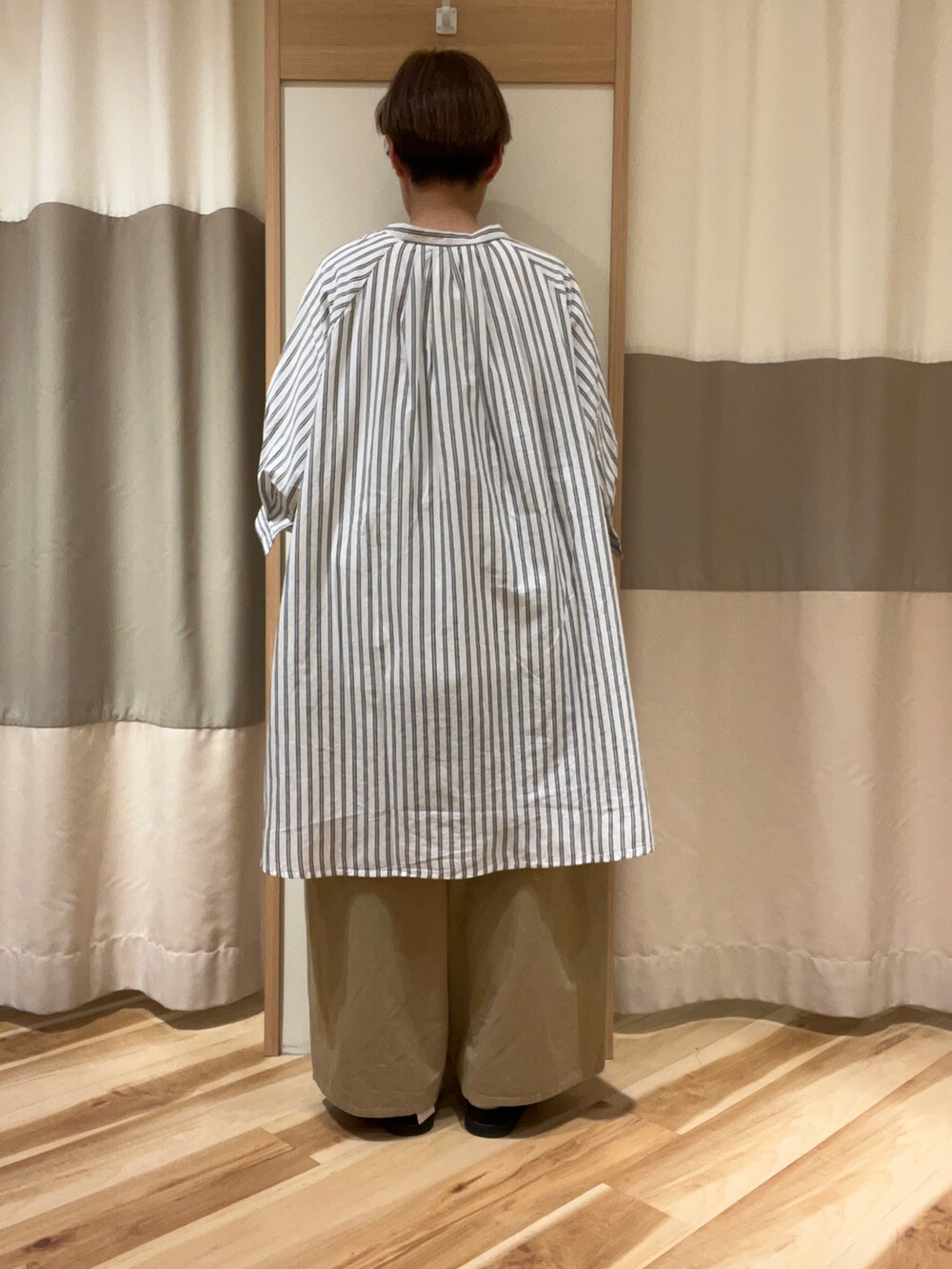 ブラック系のサンダル、ベージュ系のその他パンツ、ホワイト系のTシャツ/カットソーを着用したレディースの春コーディネートの3枚目の写真