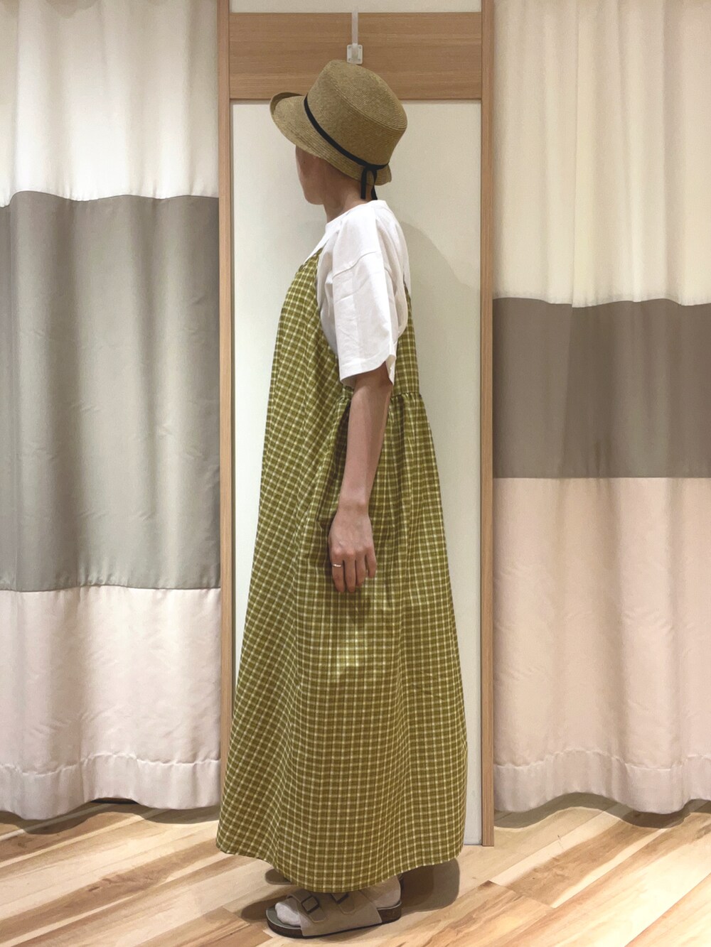 ホワイト系のハンドバッグ、イエロー系のワンピース、ホワイト系のTシャツ/カットソーを着用したレディースの夏コーディネートの2枚目の写真