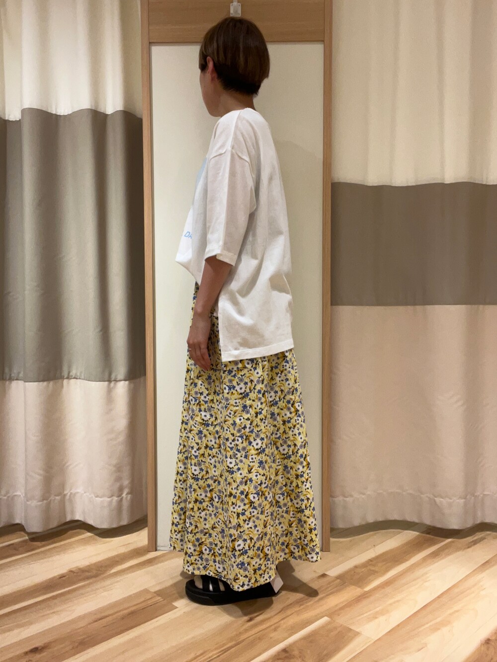 イエロー系のスカート、ホワイト系のTシャツ/カットソーを着用したレディースの春コーディネートの2枚目の写真