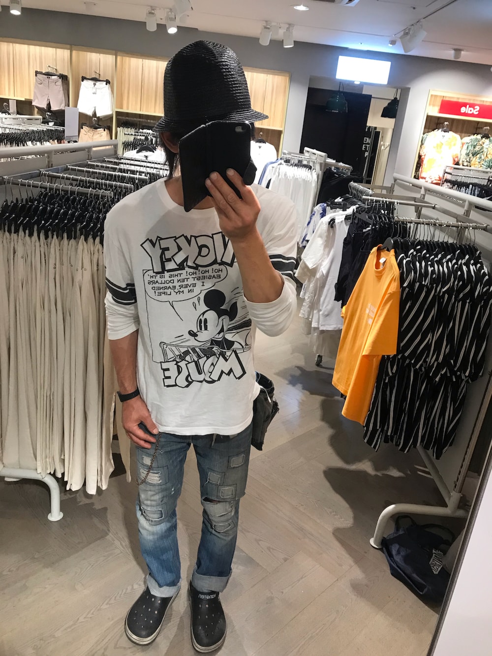 ブルー系のデニムパンツ、グレー系のトートバッグ、ブラック系のサンダルを着用したメンズの夏コーディネートの2枚目の写真