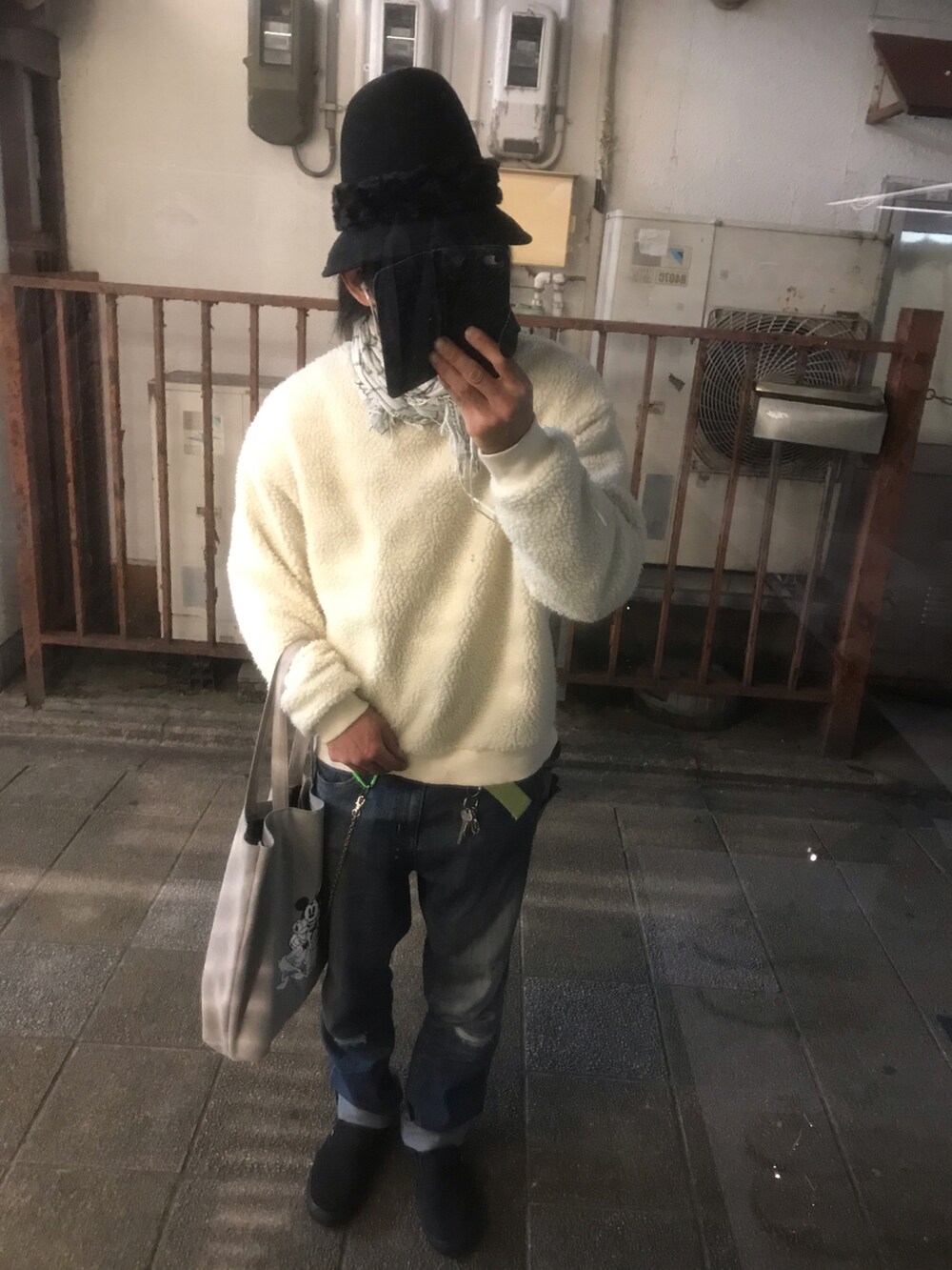 ブルー系のデニムパンツ、ブラック系のスリッポン、グレー系のトートバッグを着用したメンズの春コーディネートの2枚目の写真