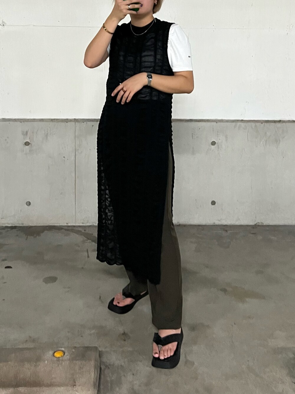 ブラック系のワンピース、ブラウン系のスラックス、ホワイト系のTシャツ/カットソーを着用したレディースの冬コーディネートの2枚目の写真