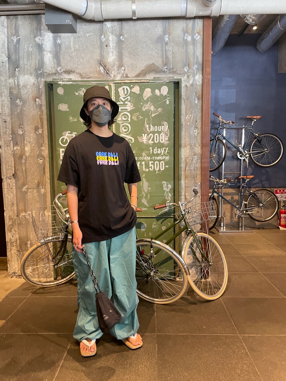 ホワイト系のサンダル、ブラック系のTシャツ/カットソー、グリーン系のその他パンツを着用したメンズの夏コーディネートの3枚目の写真