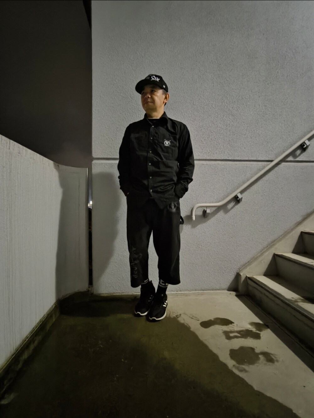 ブラック系のスニーカー、ブラック系のパンツ、ブラック系のシャツ/ブラウスを着用したメンズの冬コーディネートの3枚目の写真