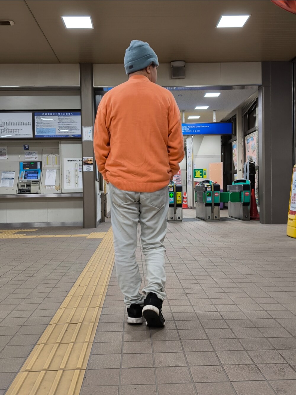 ブラック系のスニーカー、ブルー系のデニムパンツ、ピンク系のカーディガン/ボレロを着用したメンズの冬コーディネートの4枚目の写真