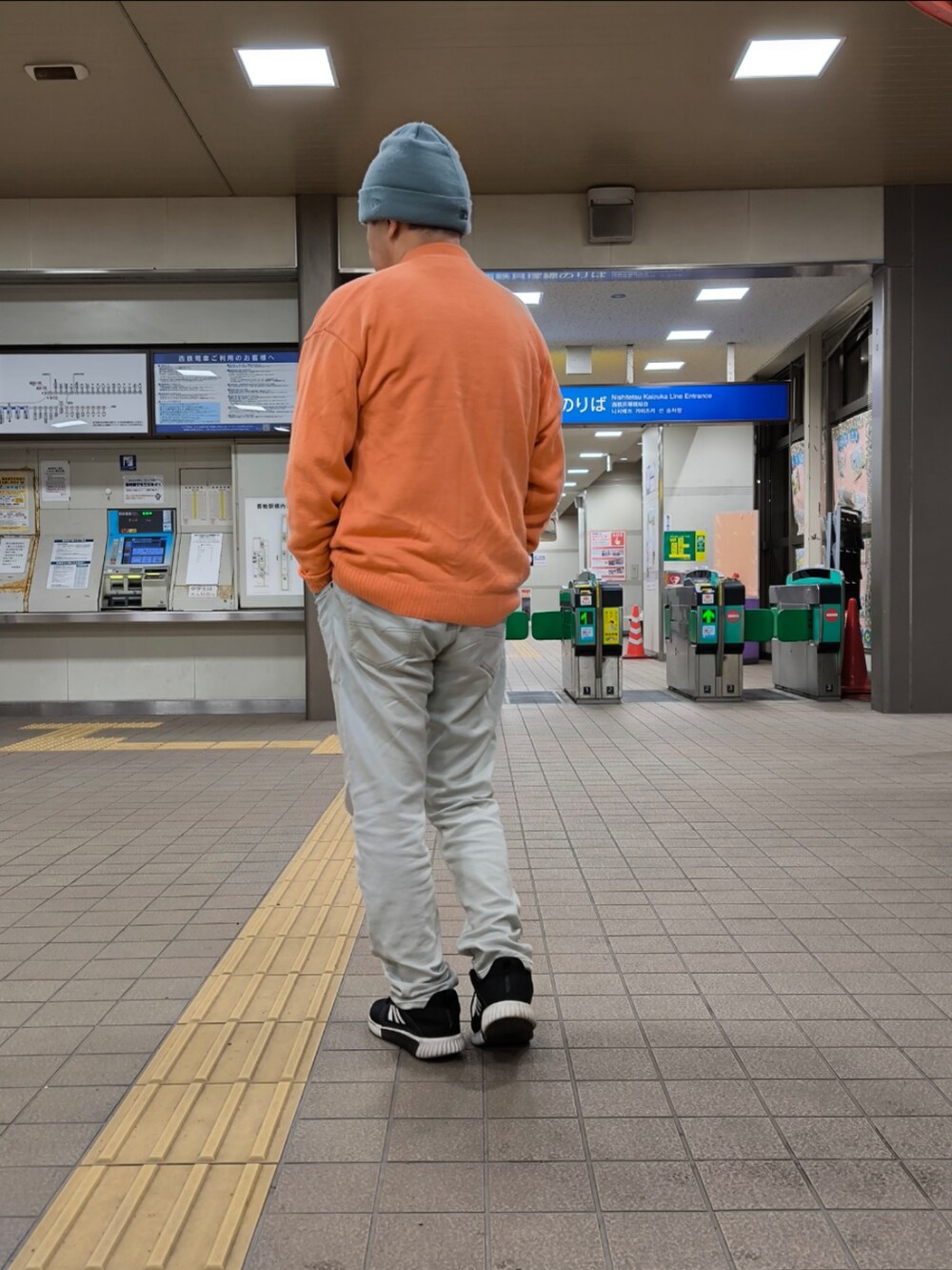 ブラック系のスニーカー、ブルー系のデニムパンツ、ピンク系のカーディガン/ボレロを着用したメンズの冬コーディネートの2枚目の写真