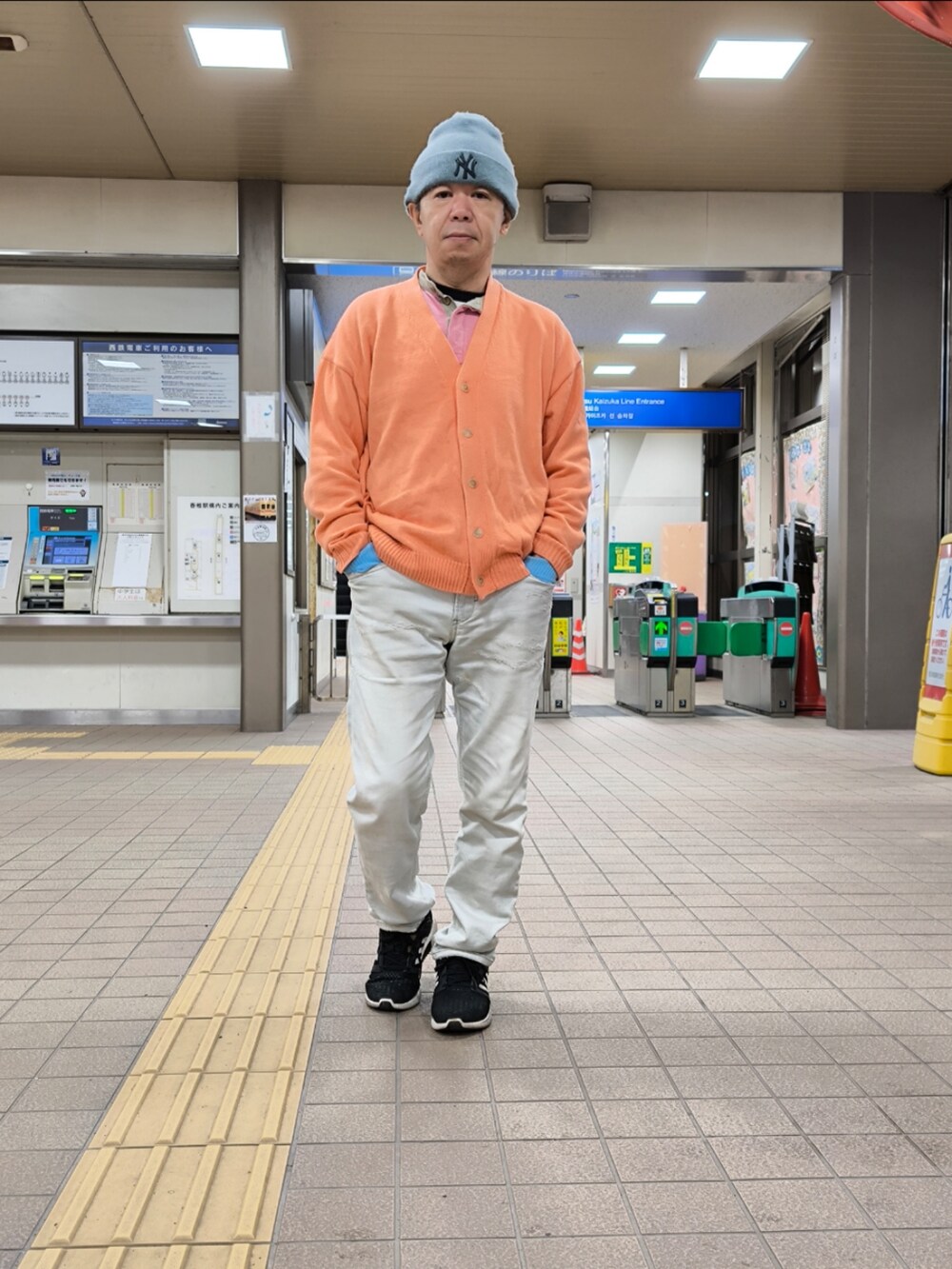 ブラック系のスニーカー、ブルー系のデニムパンツ、ピンク系のカーディガン/ボレロを着用したメンズの冬コーディネートの3枚目の写真