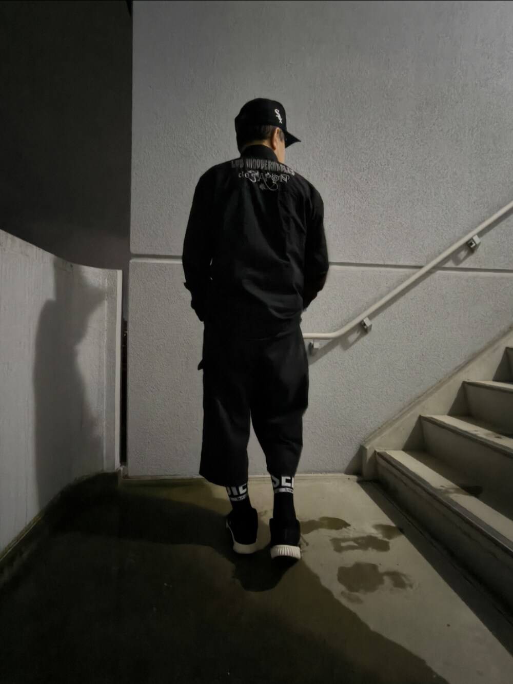 ブラック系のスニーカー、ブラック系のパンツ、ブラック系のシャツ/ブラウスを着用したメンズの冬コーディネートの4枚目の写真