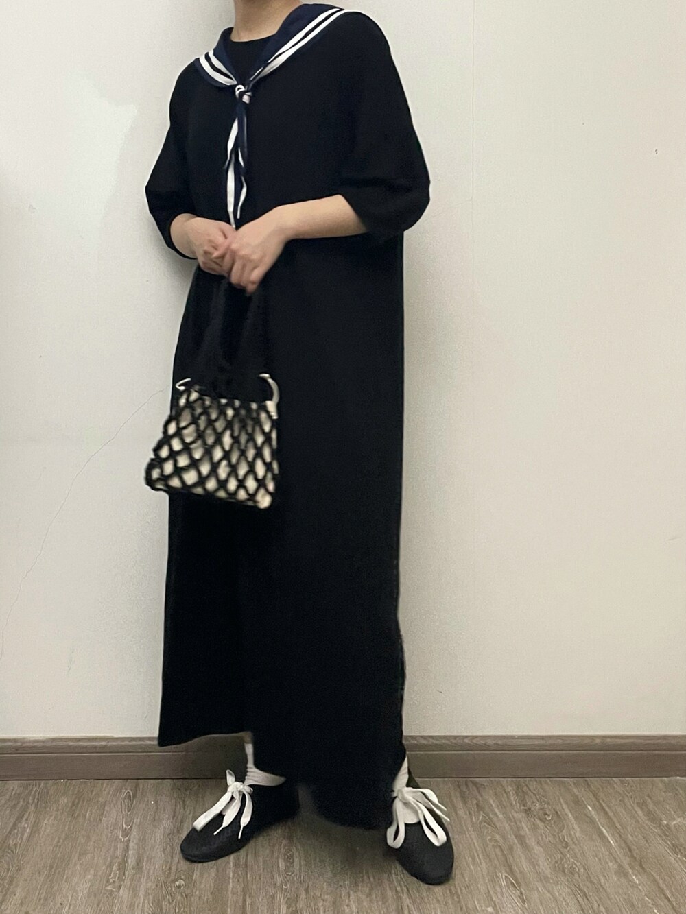 ブラック系のワンピース、ブラック系のハンドバッグ、ブラック系のシューズを着用したレディースの夏コーディネートの2枚目の写真