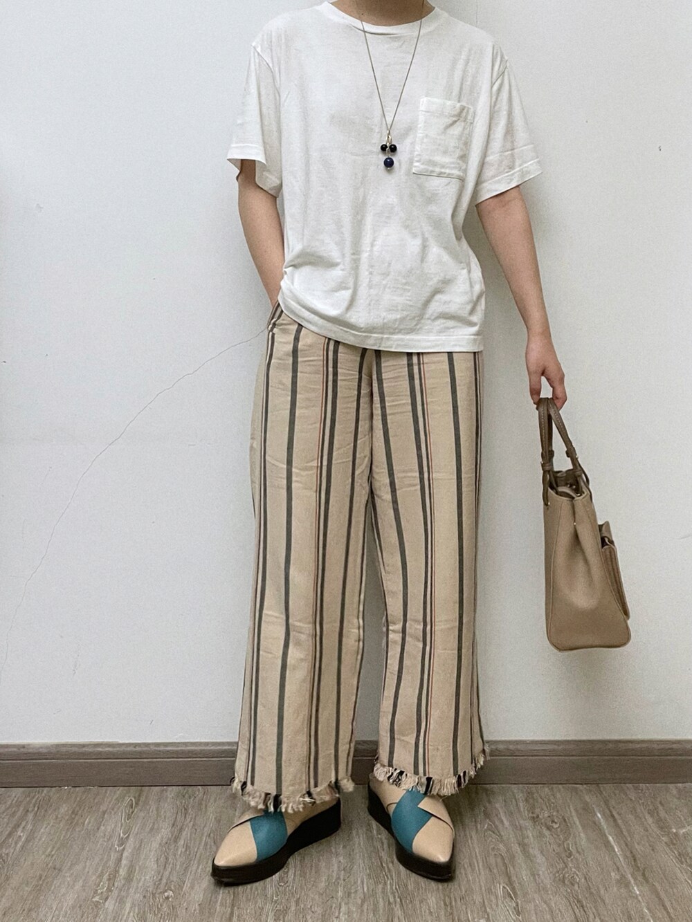 ホワイト系のTシャツ/カットソー、ベージュ系のその他パンツ、ベージュ系のサンダルを着用したレディースの夏コーディネートの2枚目の写真