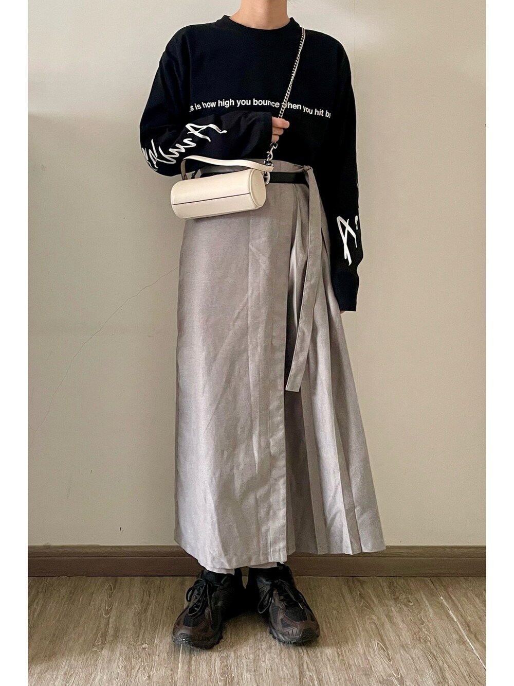 ブラック系のTシャツ/カットソー、グレー系のその他パンツ、ホワイト系のショルダーバッグを着用したレディースの春コーディネートの2枚目の写真