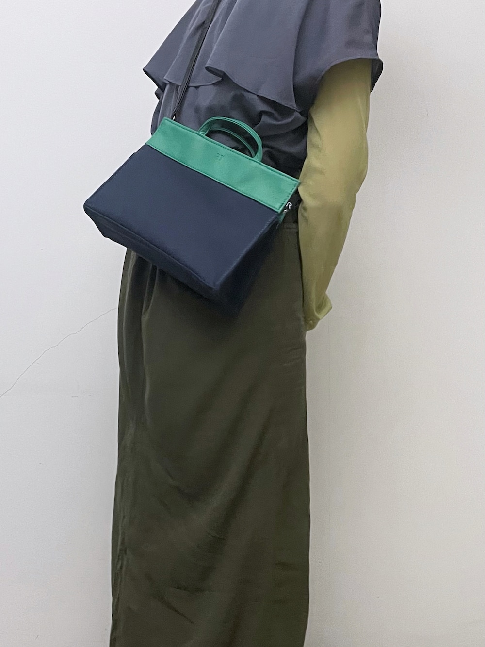 グリーン系のトップス、ブルー系のトップス、グリーン系のスカートを着用したレディースの秋コーディネートの3枚目の写真