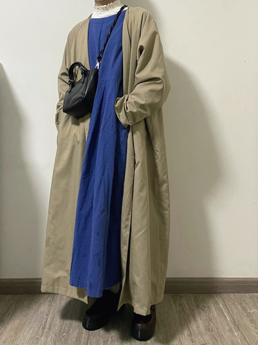 ホワイト系のTシャツ/カットソー、ブルー系のワンピース、ベージュ系のその他アウターを着用したレディースの冬コーディネートの2枚目の写真