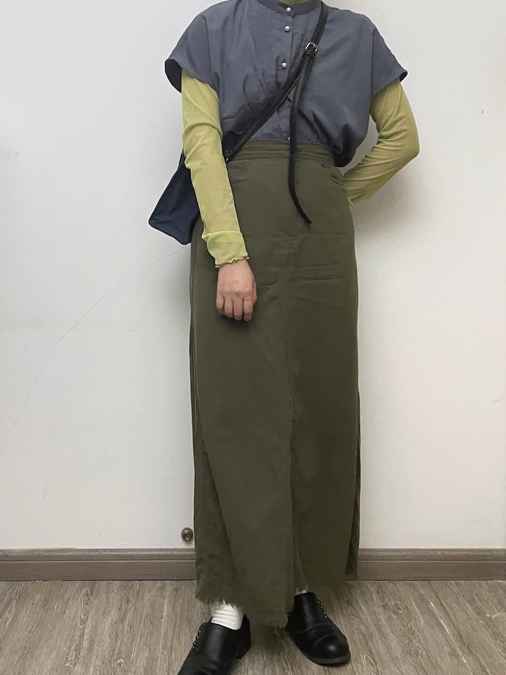 グリーン系のトップス、ブルー系のトップス、グリーン系のスカートを着用したレディースの秋コーディネートの2枚目の写真