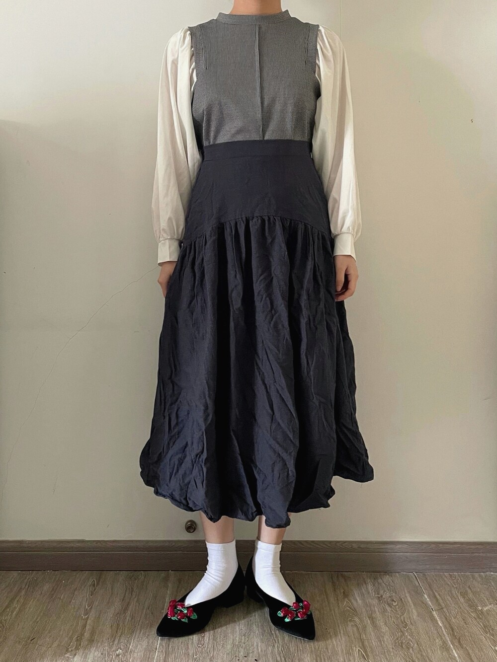 ブラック系のシャツ/ブラウス、ブルー系のスカート、ベージュ系のショルダーバッグを着用したレディースの春コーディネートの2枚目の写真