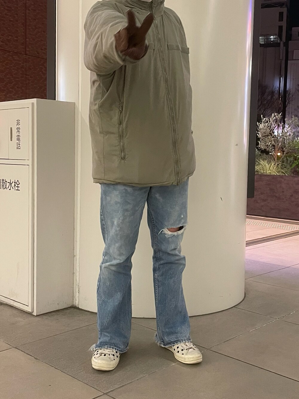 グレー系のダウンジャケット/コート、ブルー系のデニムパンツ、ホワイト系のスニーカーを着用したメンズの冬コーディネートの2枚目の写真
