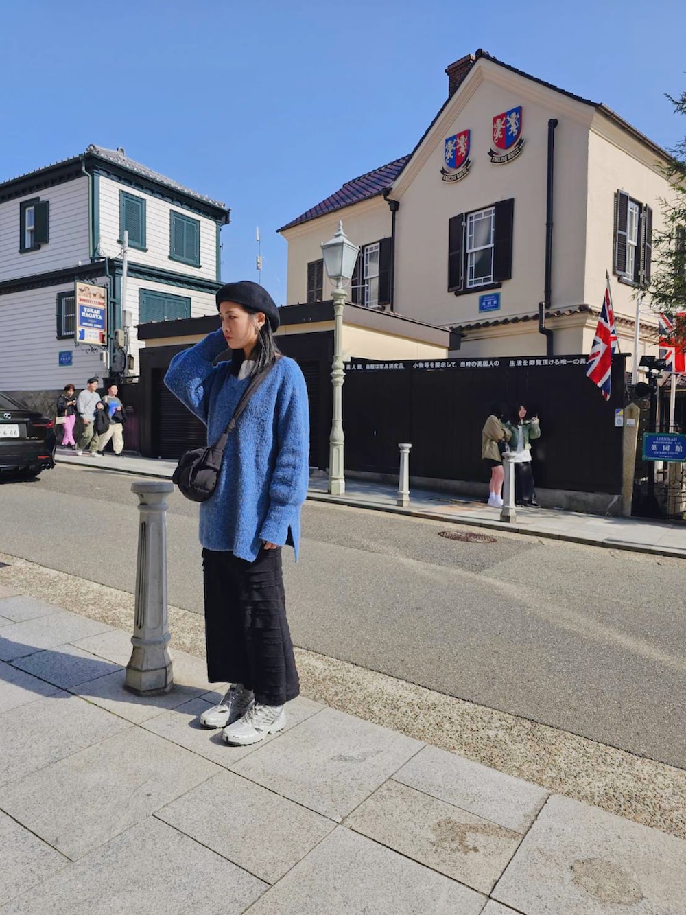 ホワイト系のニット/セーター、ブラック系のスカート、ブラック系のハンチング/ベレー帽を着用したレディースの春コーディネートの2枚目の写真