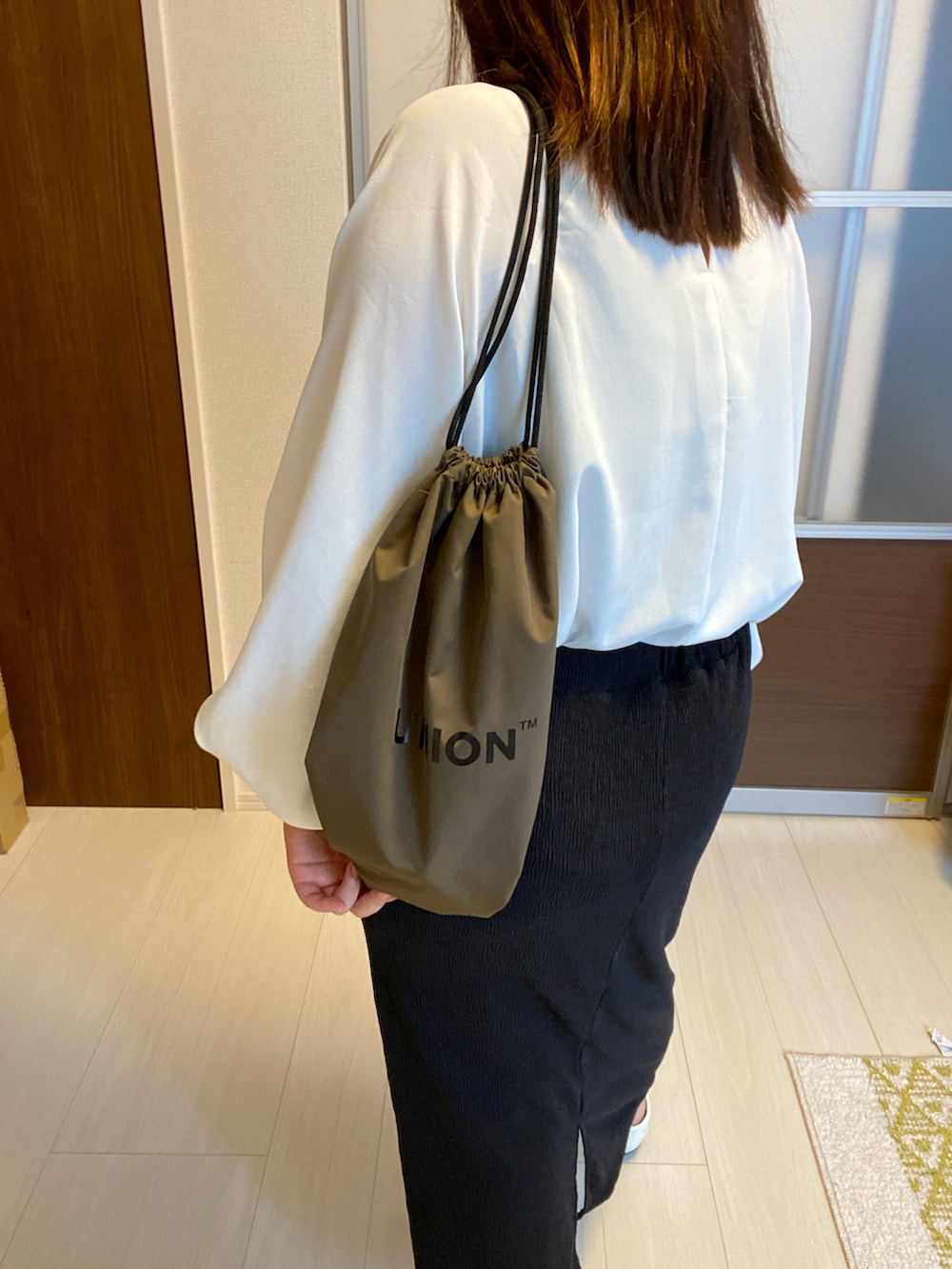 ホワイト系のシャツ/ブラウス、ブラック系のスカート、ホワイト系のローファーを着用したレディースの夏コーディネートの2枚目の写真