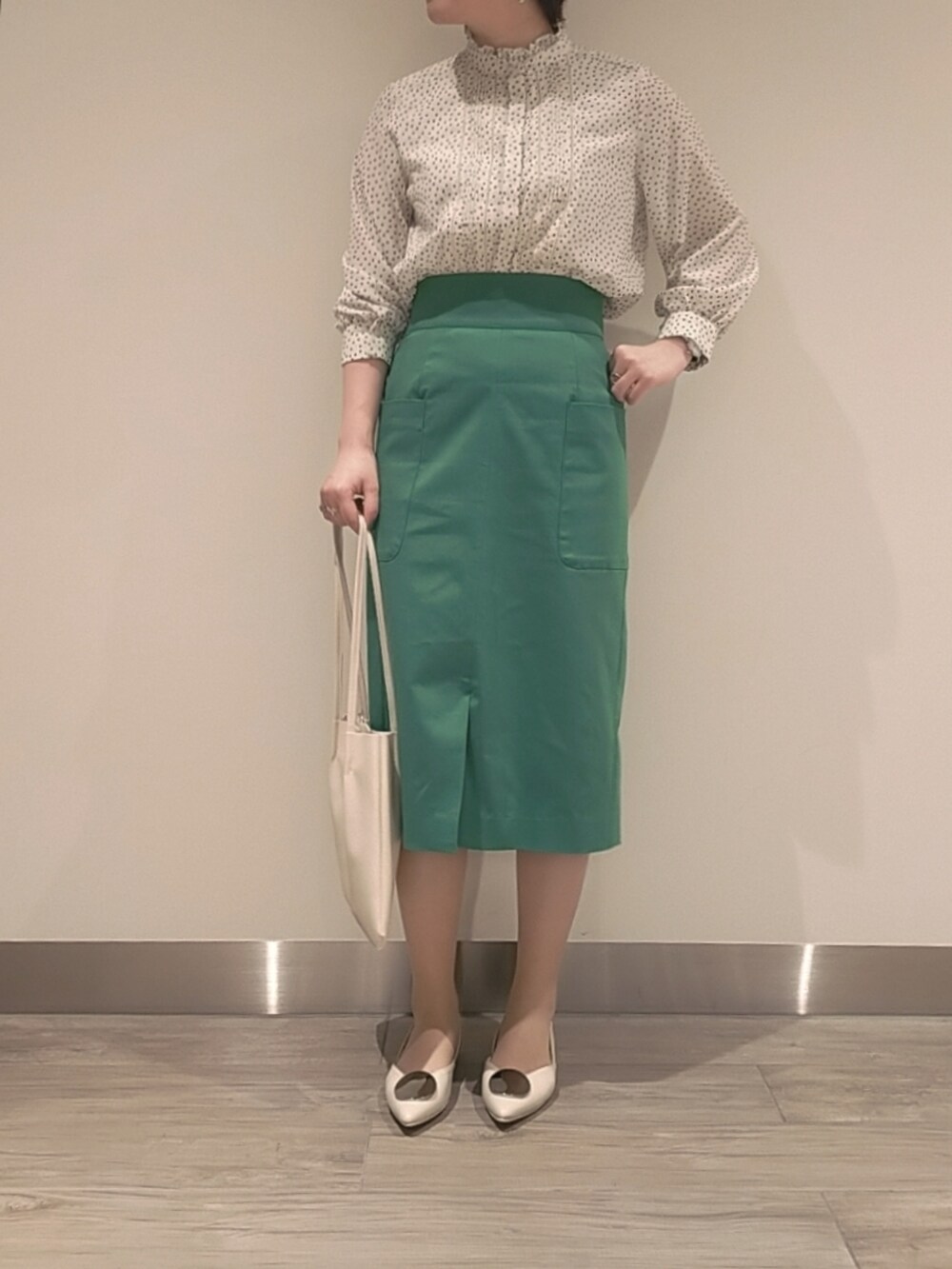 ブルー系のテーラードジャケット、グリーン系のスカート、ホワイト系のシャツ/ブラウスを着用したレディースの春コーディネートの2枚目の写真