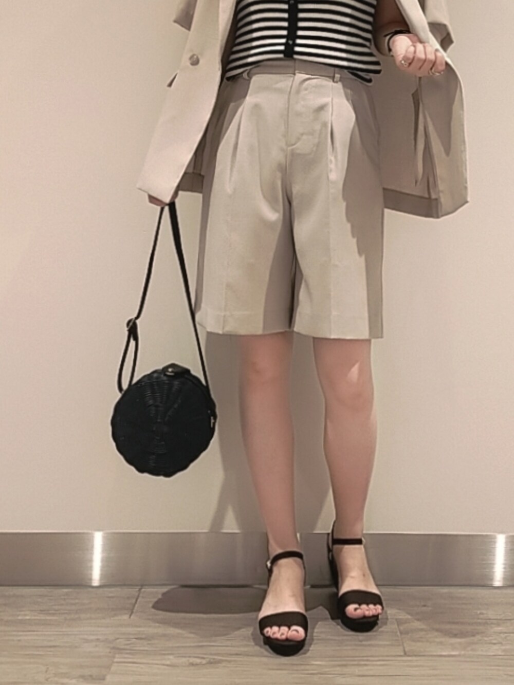 ブラウン系のサンダル、ブラック系のショルダーバッグ、ホワイト系のタンクトップを着用したレディースの夏コーディネートの3枚目の写真