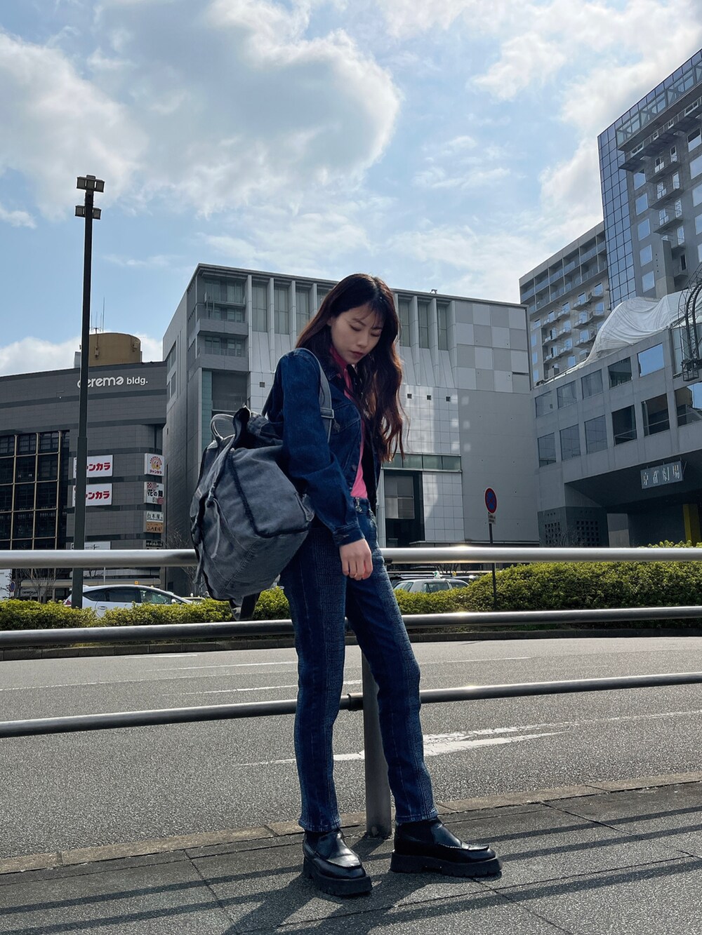 ブラック系のバックパック/リュック、ブルー系のデニムパンツ、ブルー系のジャケット/アウターを着用したレディースの春コーディネートの3枚目の写真