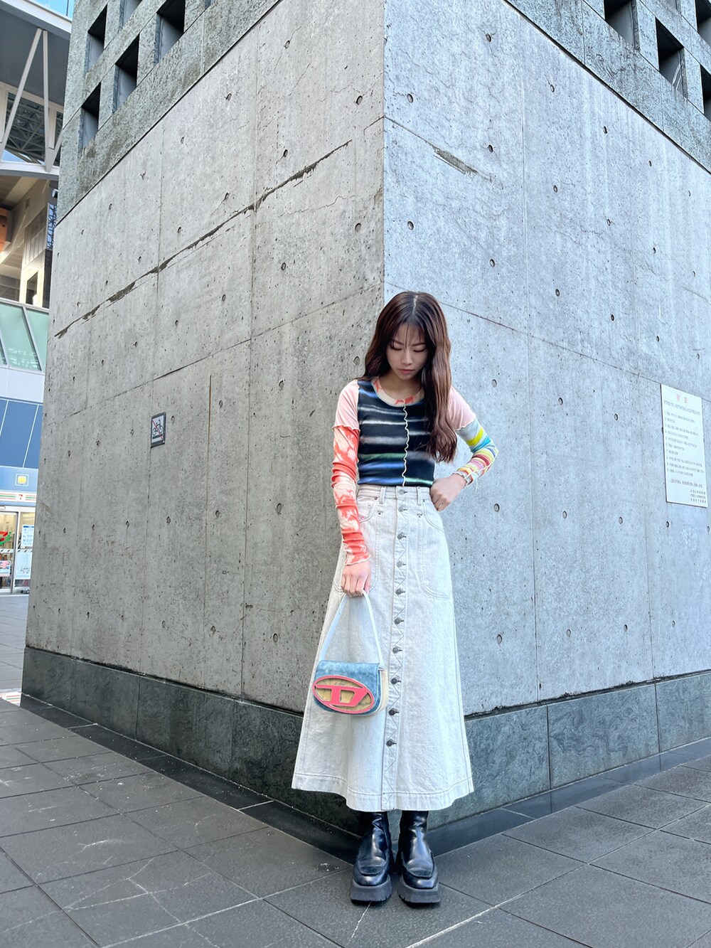 ホワイト系のデニムスカート、ブルー系のショルダーバッグ、ブラック系のTシャツ/カットソーを着用したレディースの冬コーディネートの2枚目の写真