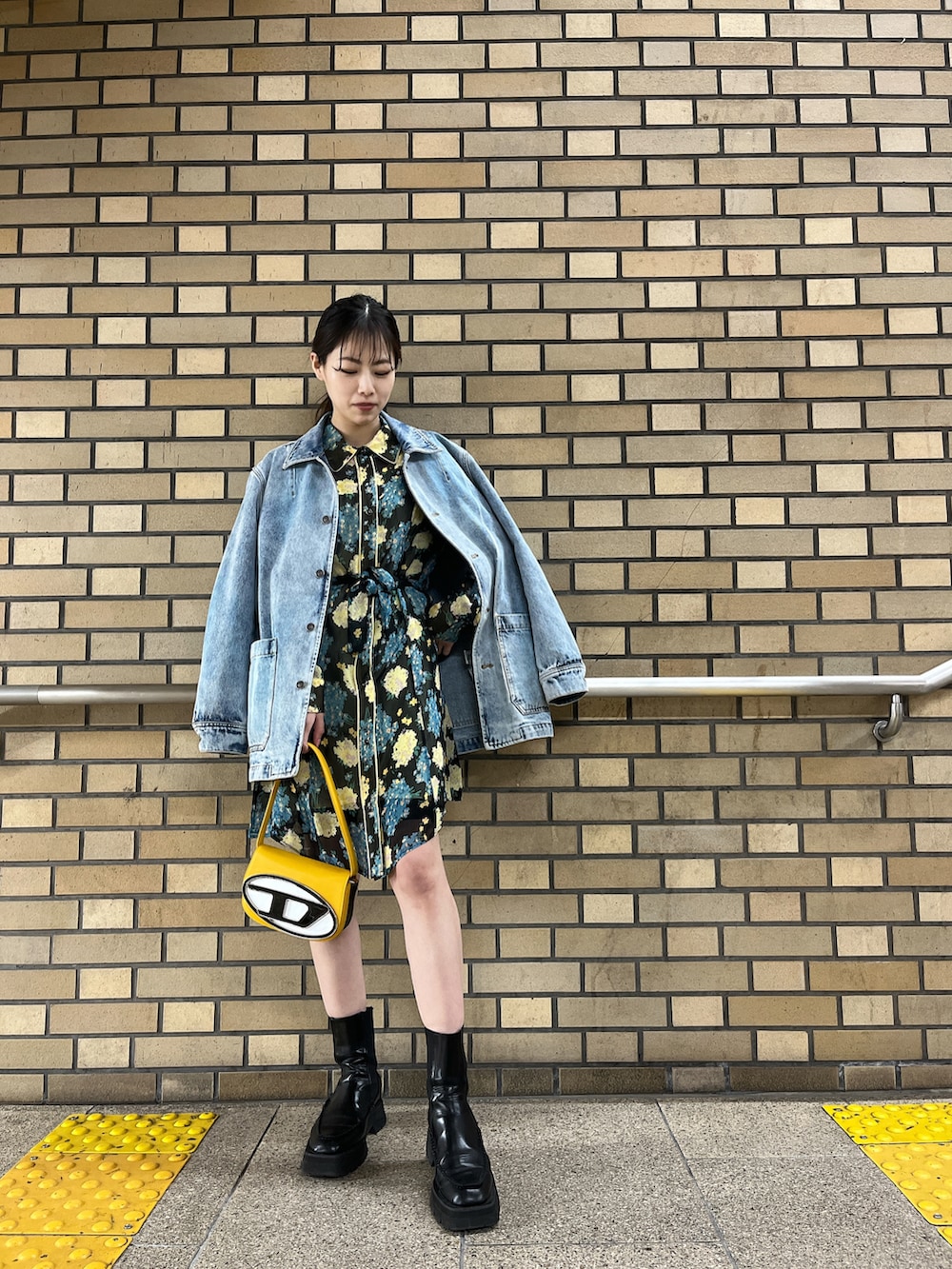 ブラック系のシャツワンピース、イエロー系のショルダーバッグ、ブルー系のデニムジャケットを着用したレディースの春コーディネートの2枚目の写真