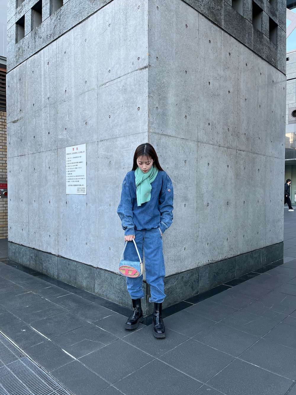 ブルー系のショルダーバッグ、ブルー系のスウェット、ブルー系のデニムパンツを着用したレディースの冬コーディネートの2枚目の写真