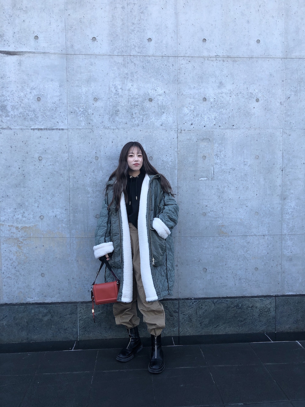 グリーン系のその他アウター、オレンジ系のショルダーバッグ、ベージュ系のその他パンツを着用したレディースの秋コーディネートの2枚目の写真