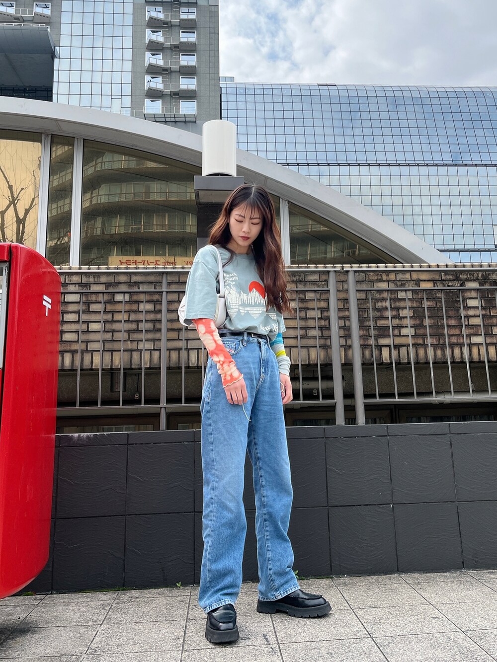 ブルー系のデニムパンツ、ホワイト系のショルダーバッグ、グレー系のTシャツ/カットソーを着用したレディースの春コーディネートの2枚目の写真